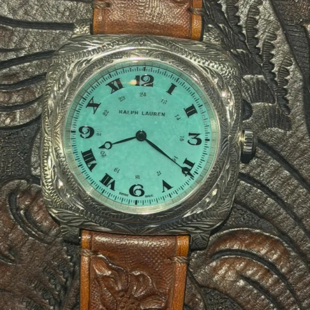 Blending American heritage with Swiss haute horlogerie, Ralph Lauren’s RL Western Cushion Turquoise embodies a unique vision of contemporary luxury. This new creation from the American Western collection celebrates the aesthetic world dear to Ralph Lauren, inspired by the American wilderness, vintage concho belts, and the authentic spirit of Santa Fe.
Featuring a spectacular dial crafted from natural turquoise stone, each watch reveals unique hues and inclusions, making every piece truly one-of-a-kind. This iconic stone, deeply associated with the craftsmanship of the American Southwest, lends a strong personality to this bold cushion-shaped watch. @ralphlauren western watches available @chronopassion authorized retailer
